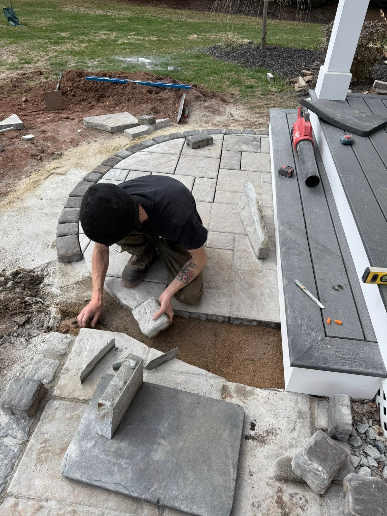 Pete's Lawn Care crew member installing bluestone paver patio in Southington CT